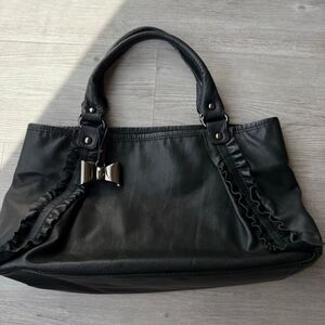 Tous leather black tote bag with ruffled trim and a bow charm